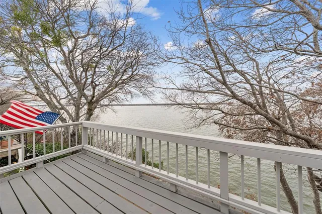 a balcony with wooden floor and trees