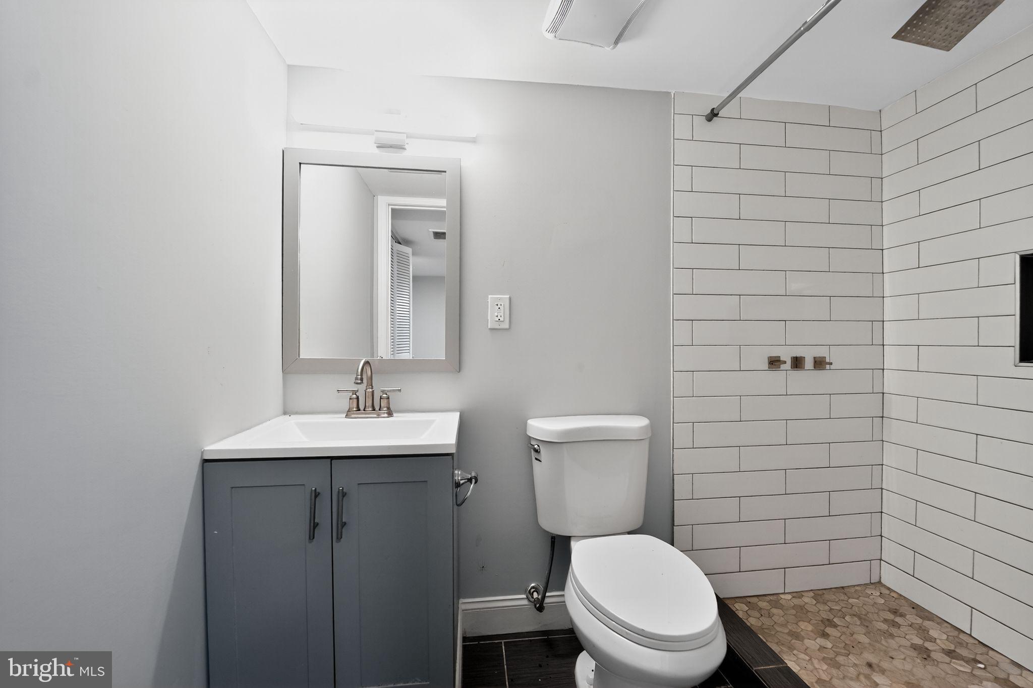 3807 Elkader Road Baltimore, MD 21218 - Photo 12 of 30 a bathroom with a toilet a sink and mirror