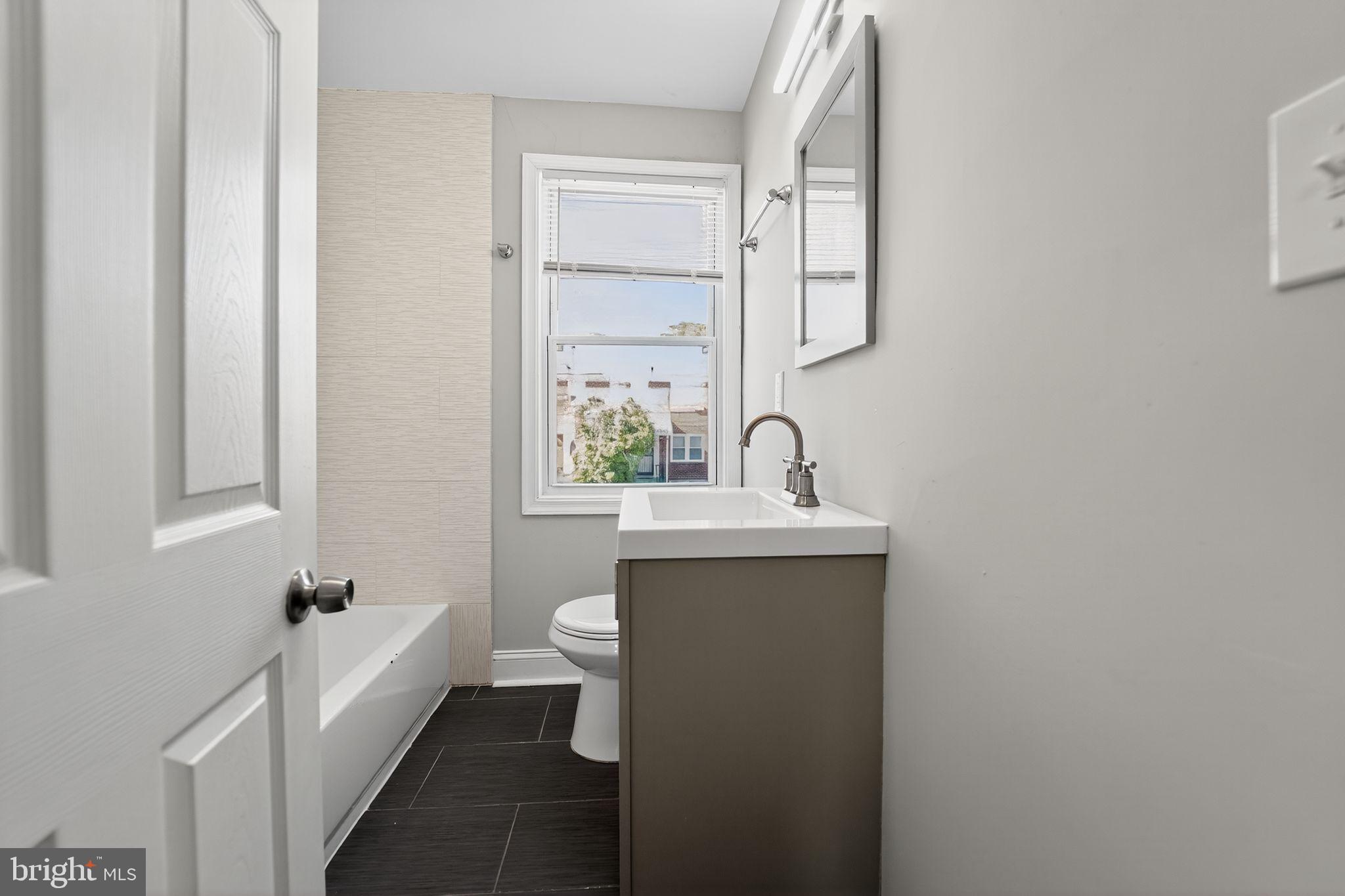 3807 Elkader Road Baltimore, MD 21218 - Photo 13 of 30 a bathroom with a sink a toilet and mirror