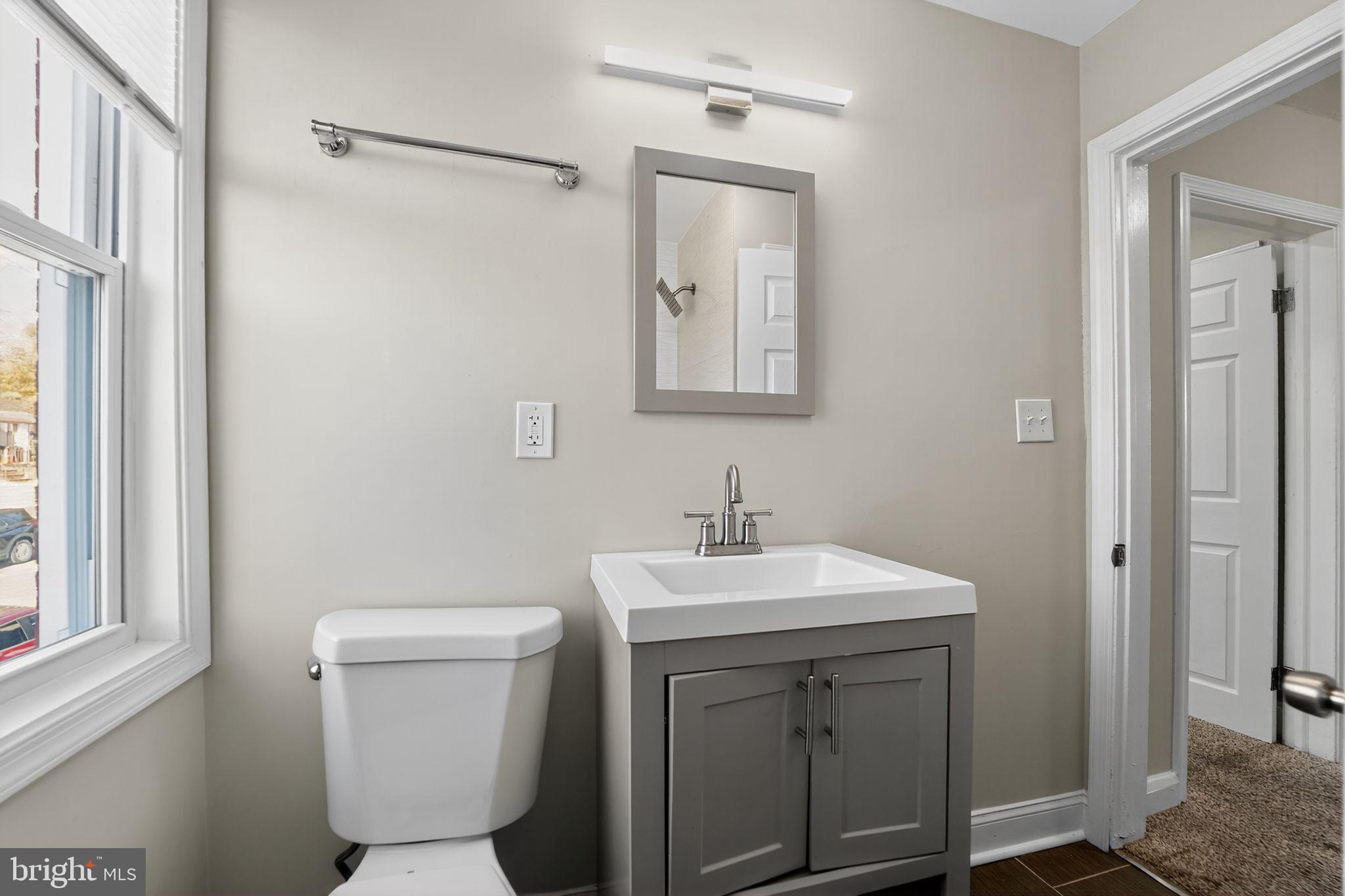 3807 Elkader Road Baltimore, MD 21218 - Photo 14 of 30 a bathroom with a toilet sink and mirror