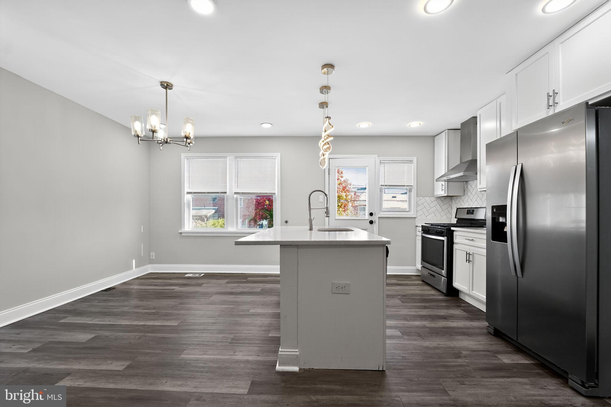3807 Elkader Road Baltimore, MD 21218 - Photo 4 of 30 a kitchen with kitchen island a sink counter top space stainless steel appliances and cabinets