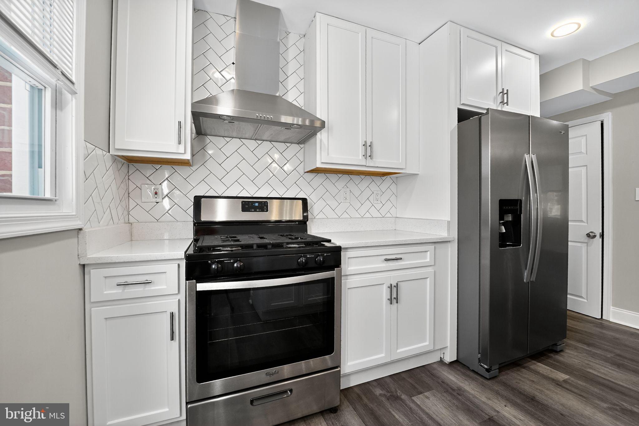 3807 Elkader Road Baltimore, MD 21218 - Photo 5 of 30 a kitchen with stainless steel appliances white cabinets and a stove