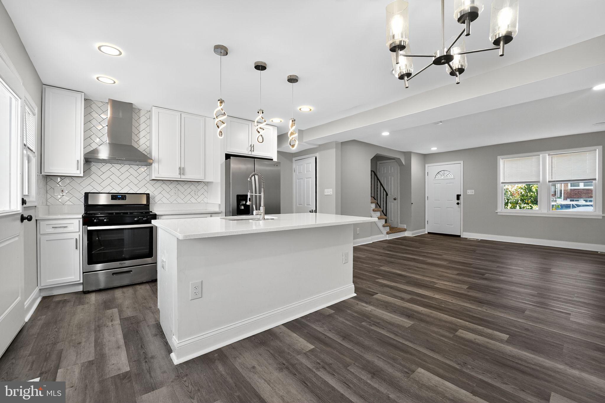 3807 Elkader Road Baltimore, MD 21218 - Photo 8 of 30 a large white kitchen with sink and refrigerator