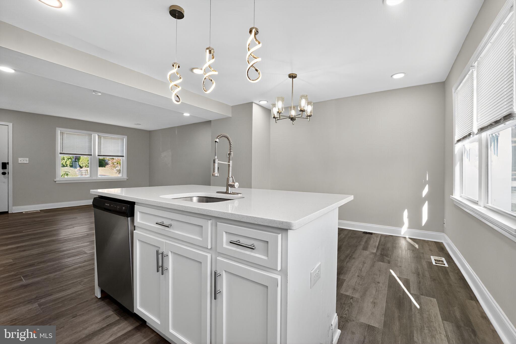 3807 Elkader Road Baltimore, MD 21218 - Photo 9 of 30 a bathroom with a sink a chandelier and wooden floor