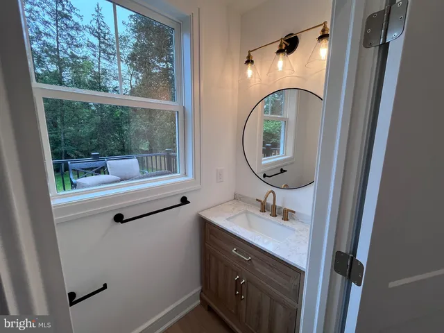 a bathroom with a sink a mirror a vanity and window