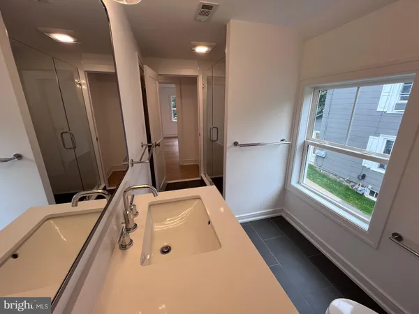 a bathroom with a tub sink and mirror