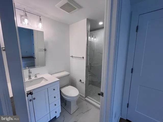 a bathroom with a granite countertop sink toilet and shower
