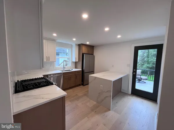a kitchen with a sink a stove cabinets and wooden floor