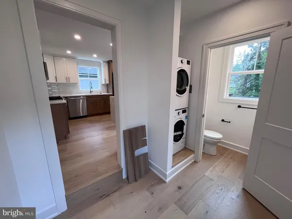 a bathroom with a sink a toilet a shower and a window