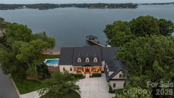 an aerial view of a house with lake view and a trees