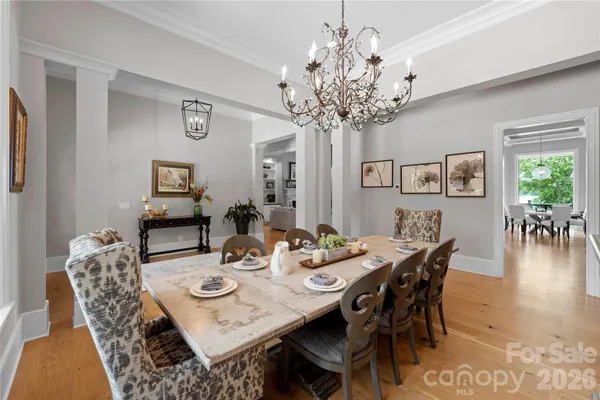a kitchen with stainless steel appliances kitchen island granite countertop a table chairs sink and cabinets