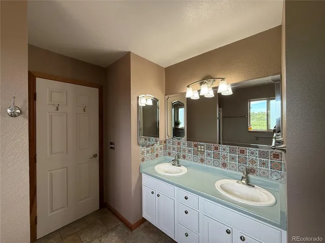 a bathroom with a double vanity sink and a mirror