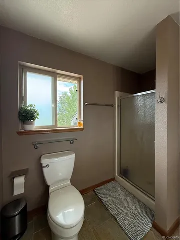 a bathroom with a toilet a sink and a window