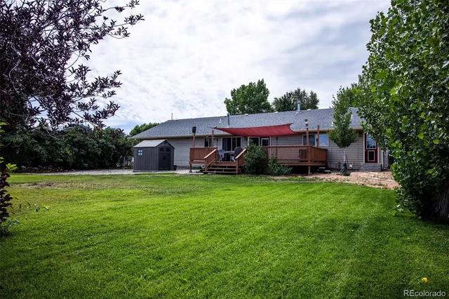 a view of a house with a big yard plants and large trees