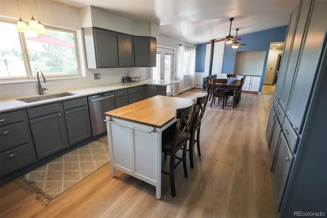 a kitchen with stainless steel appliances granite countertop a sink a stove a dining table and chairs