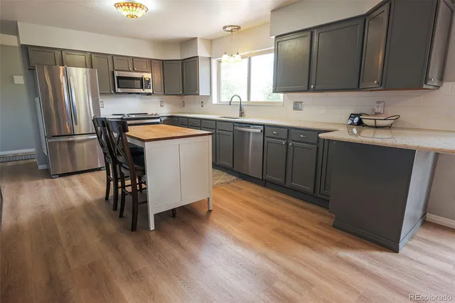 a kitchen with a sink a microwave a refrigerator and cabinets