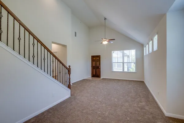 an empty room with windows and chandelier