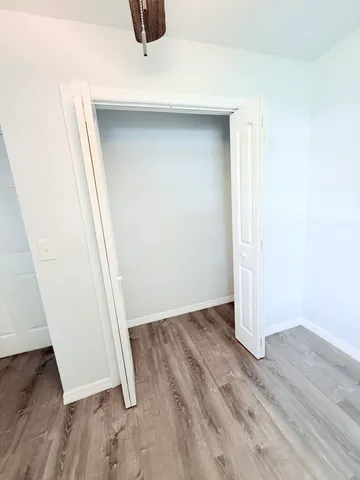 an empty room with wooden floor and entrance