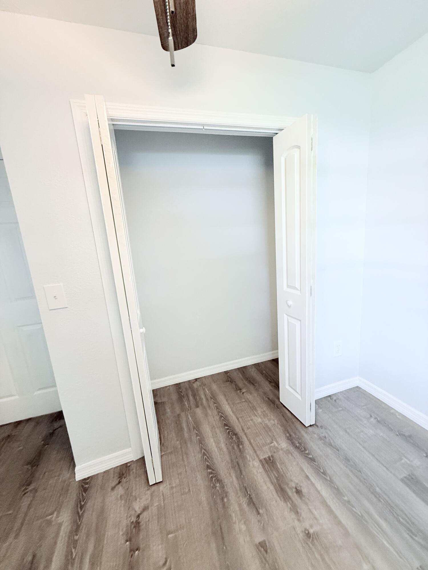 1025 Ash Circle Okeechobee, FL 34974 - Photo 12 of 26 an empty room with wooden floor and entrance