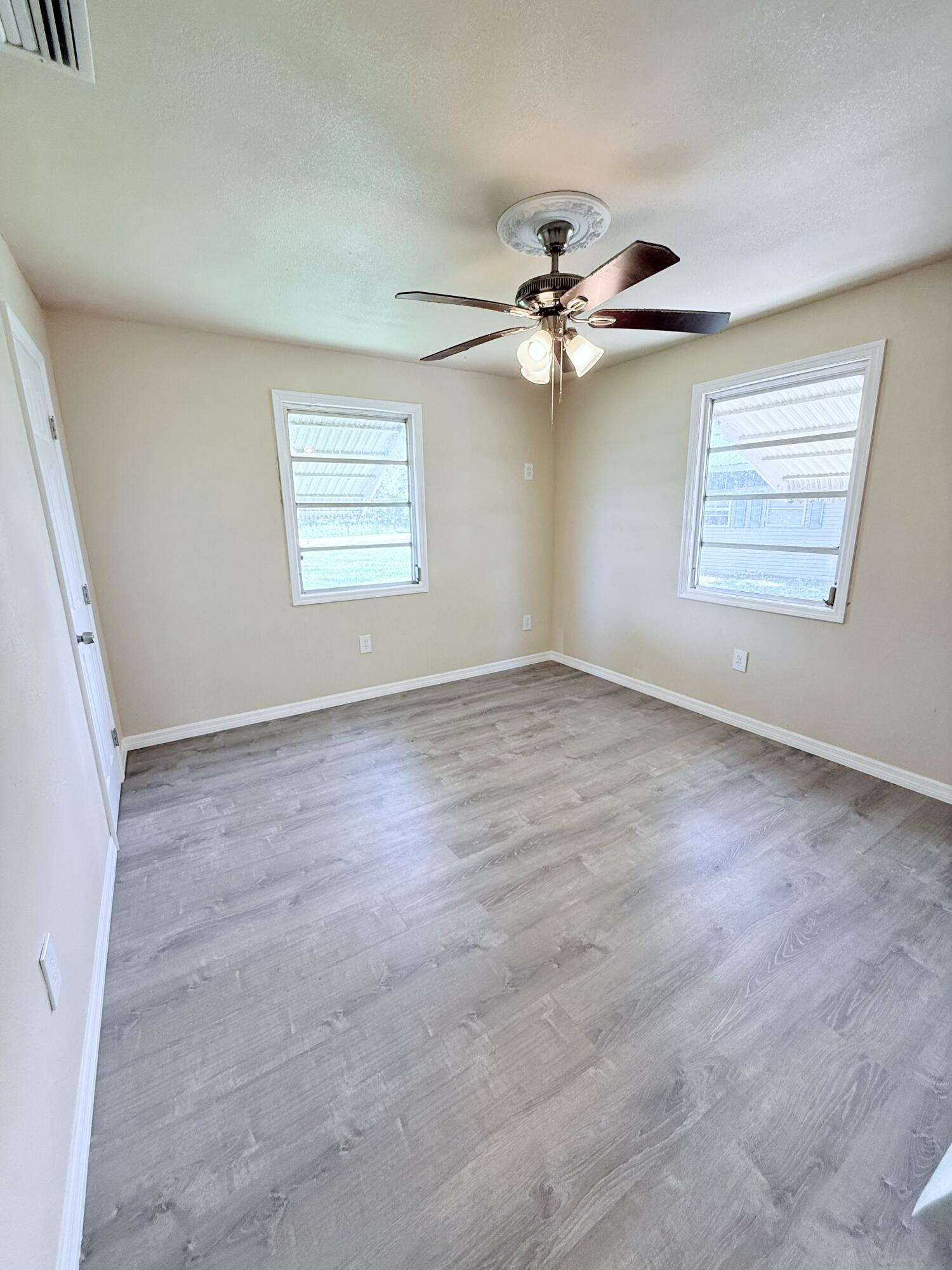 1025 Ash Circle Okeechobee, FL 34974 - Photo 17 of 26 an empty room with windows and fan