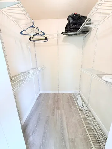 a view of a room with wooden floor and cabinets