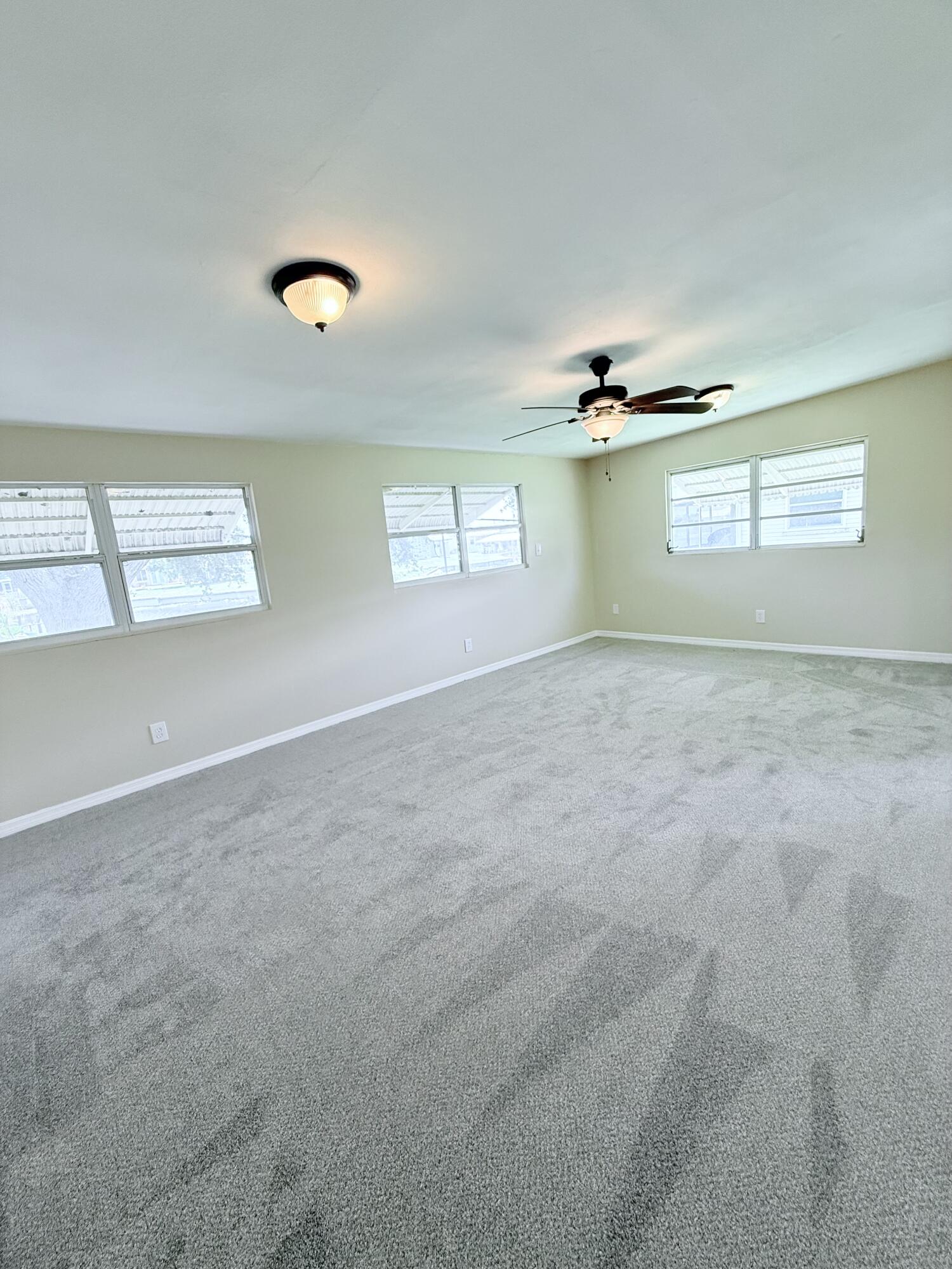 1025 Ash Circle Okeechobee, FL 34974 - Photo 20 of 26 an empty room with windows and cabinet