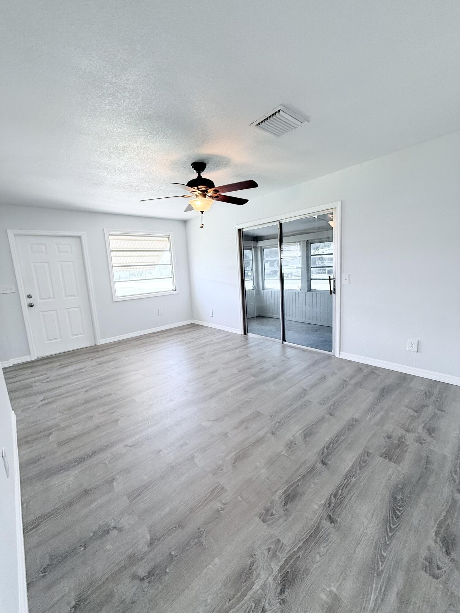 1025 Ash Circle Okeechobee, FL 34974 - Photo 6 of 26 a view of empty room with wooden floor and fan