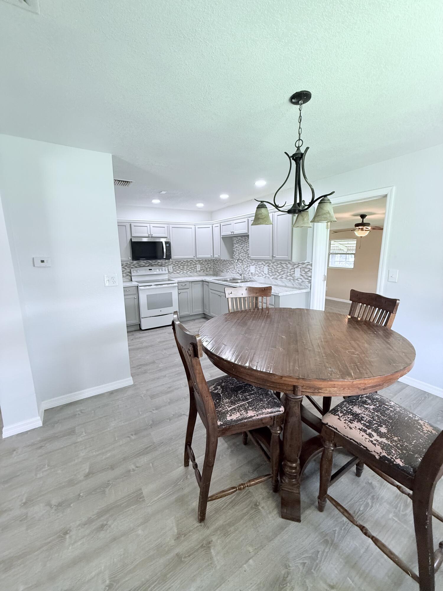 1025 Ash Circle Okeechobee, FL 34974 - Photo 7 of 26 a dining room with furniture and wooden floor