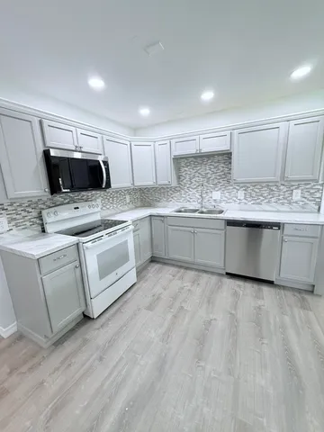 a kitchen with granite countertop a sink and cabinets
