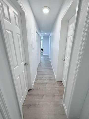 a view of a hallway with wooden floor and entryway