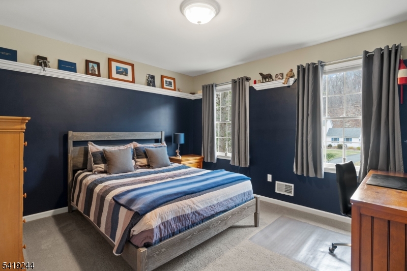 57 Paderewski Road Oak Ridge, NJ 07438 - Photo 17 of 42 a bedroom with a bed bookshelf and a large window