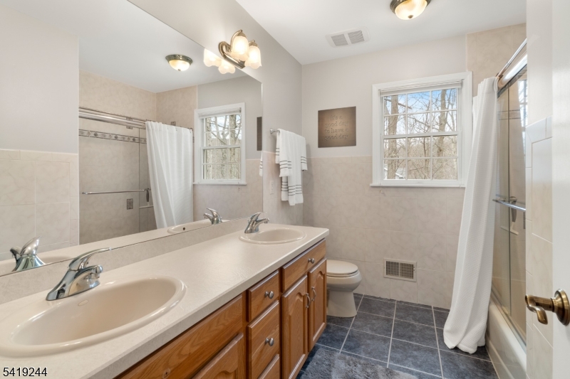 57 Paderewski Road Oak Ridge, NJ 07438 - Photo 18 of 42 a bathroom with a sink a toilet a mirror and a shower