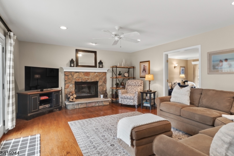 57 Paderewski Road Oak Ridge, NJ 07438 - Photo 34 of 42 a living room with furniture a flat screen tv and a fireplace