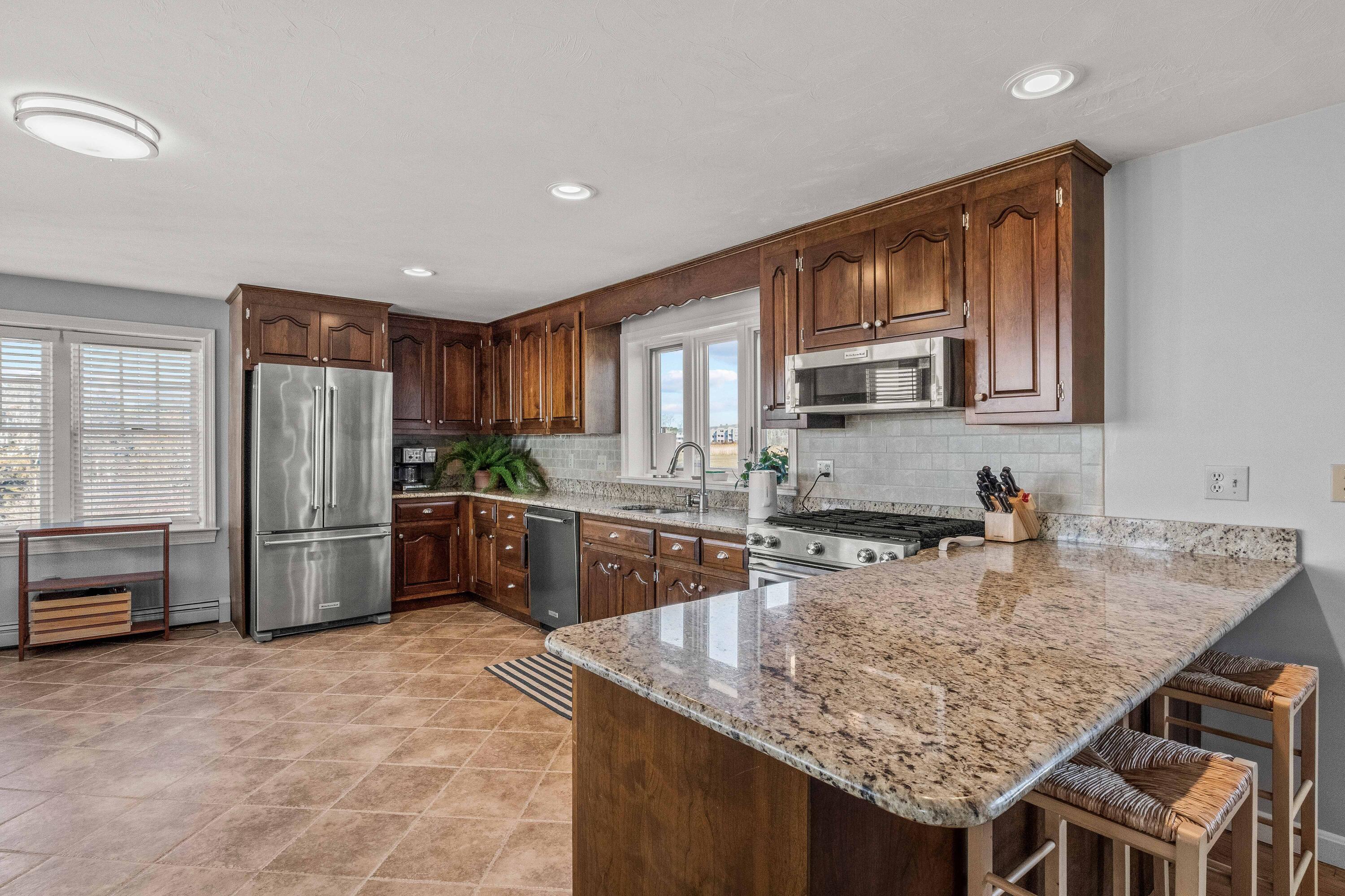 356 Lower County Road Harwich Port, MA 02646 - Photo 11 of 27 a kitchen with stainless steel appliances granite countertop a stove refrigerator and cabinets