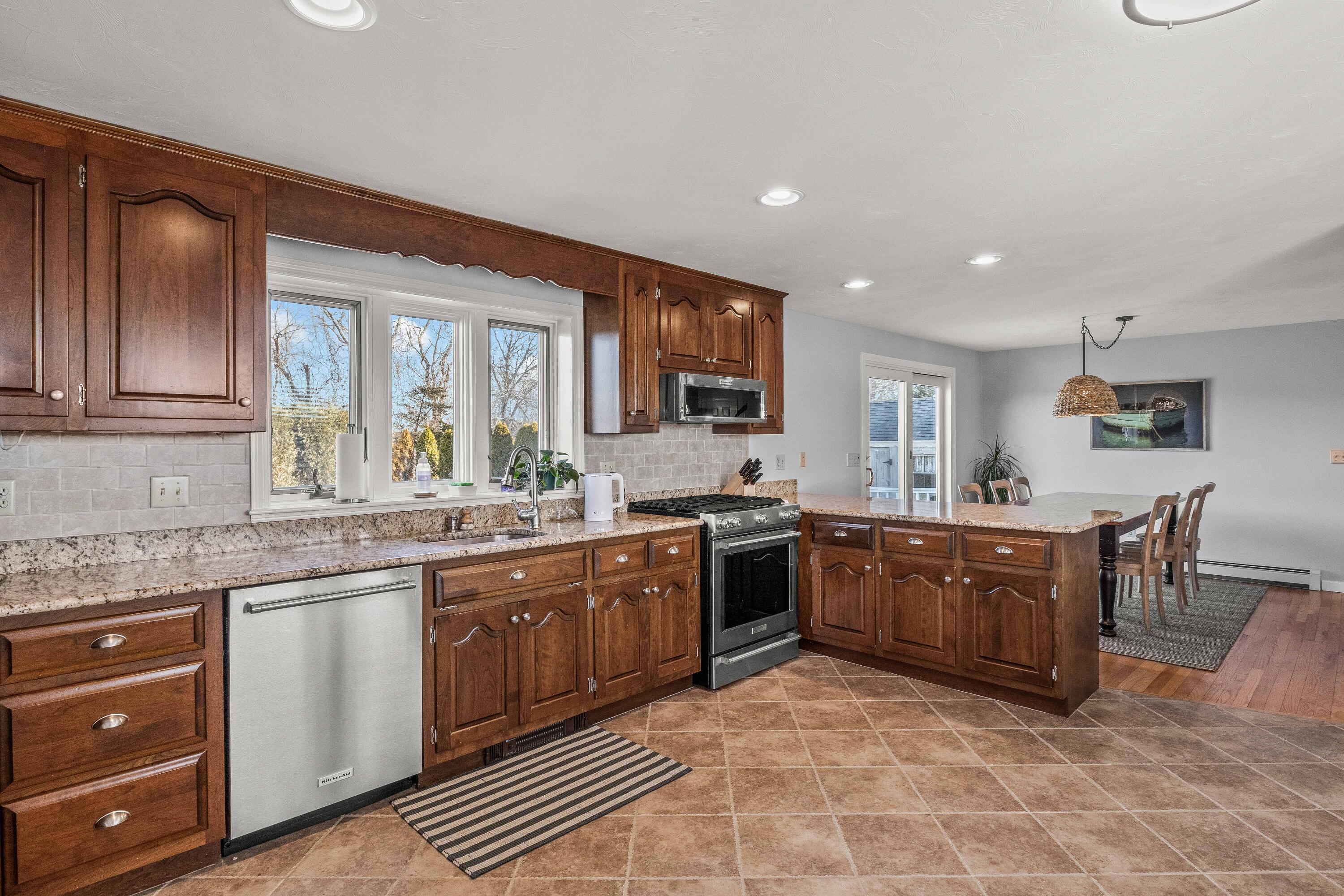 356 Lower County Road Harwich Port, MA 02646 - Photo 13 of 27 a large kitchen with stainless steel appliances granite countertop a stove sink and cabinets