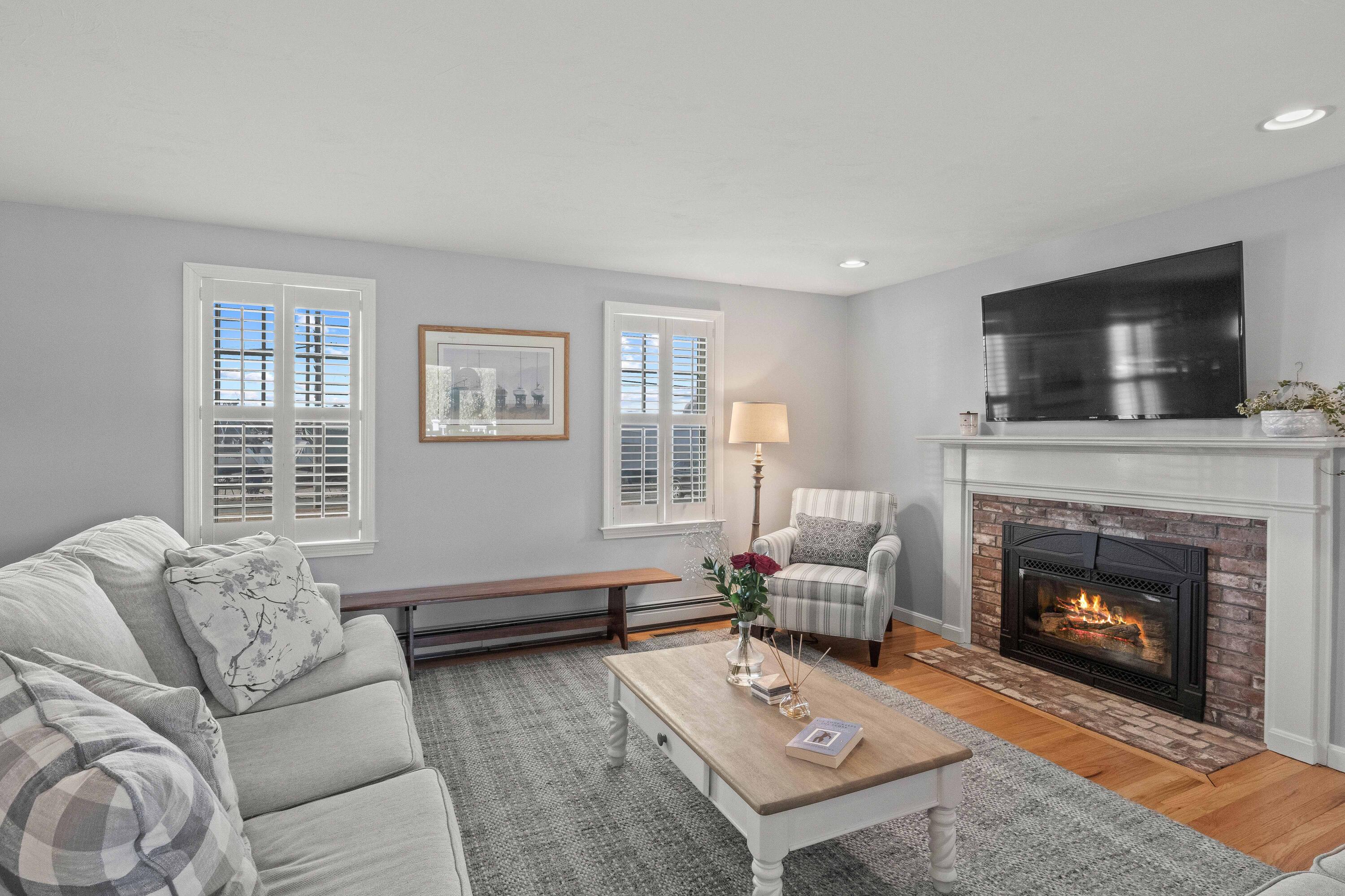 356 Lower County Road Harwich Port, MA 02646 - Photo 8 of 27 a living room with furniture a flat screen tv and a fireplace