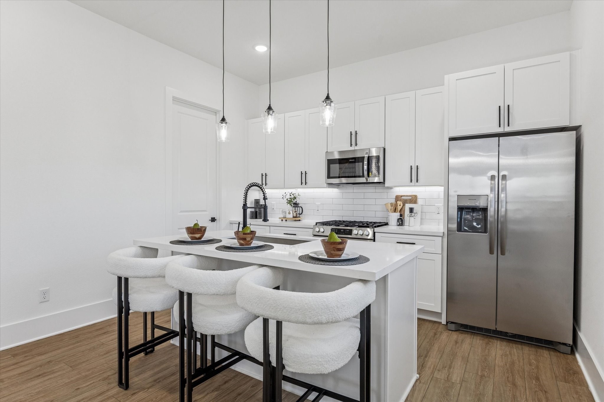 5616 Azores Houston, TX 77091 - Photo 19 of 38 a kitchen with a dining table chairs refrigerator and microwave