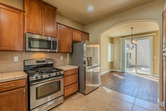 a kitchen with granite countertop a refrigerator and a stove top oven