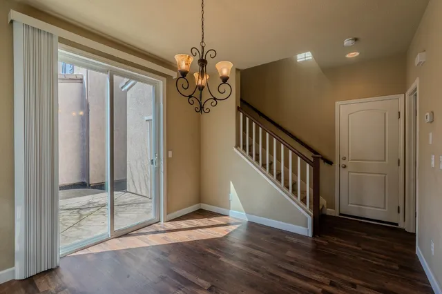 a view of a hallway with wooden floor and stairs