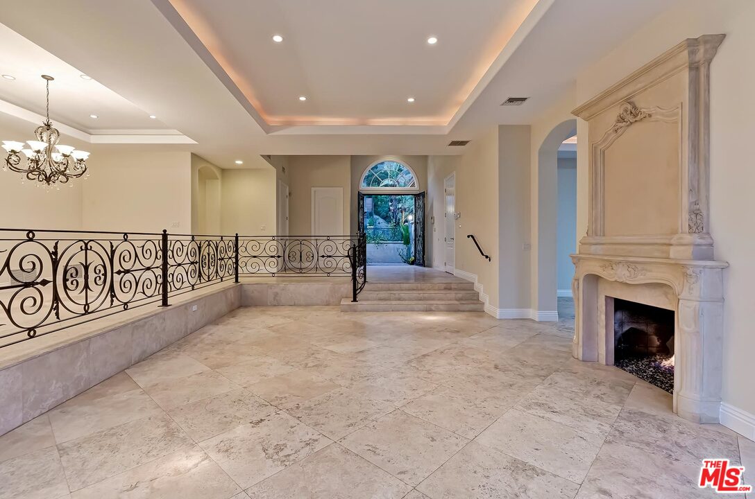 2121 Mt Olympus Drive Los Angeles, CA 90046 - Photo 13 of 34 a view of a hallway with a fireplace and chandelier