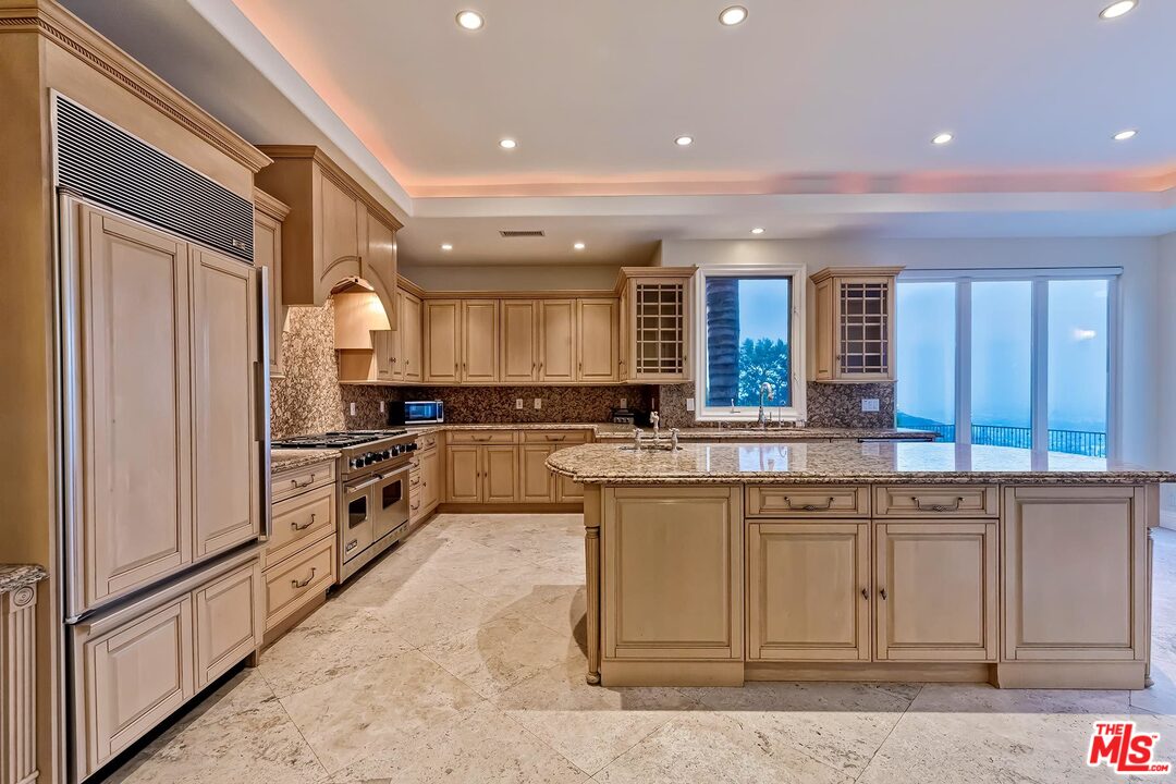 2121 Mt Olympus Drive Los Angeles, CA 90046 - Photo 16 of 34 a kitchen with stainless steel appliances granite countertop a refrigerator a stove and a sink