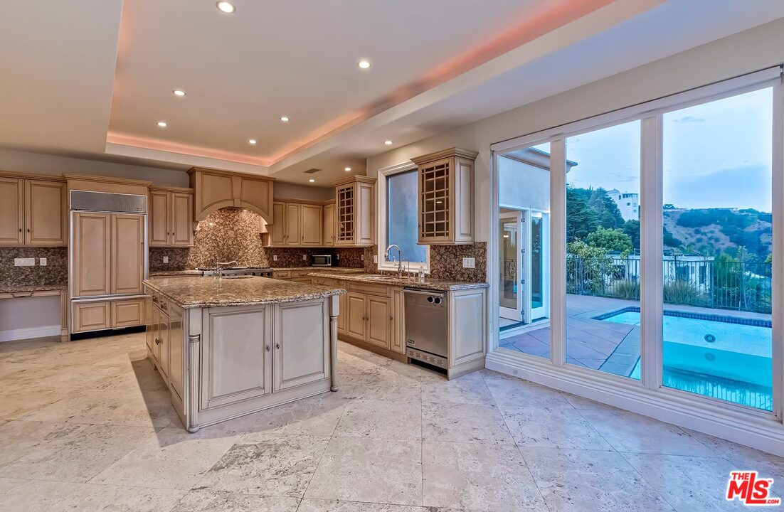 2121 Mt Olympus Drive Los Angeles, CA 90046 - Photo 18 of 34 a kitchen with granite countertop a stove a sink and a refrigerator