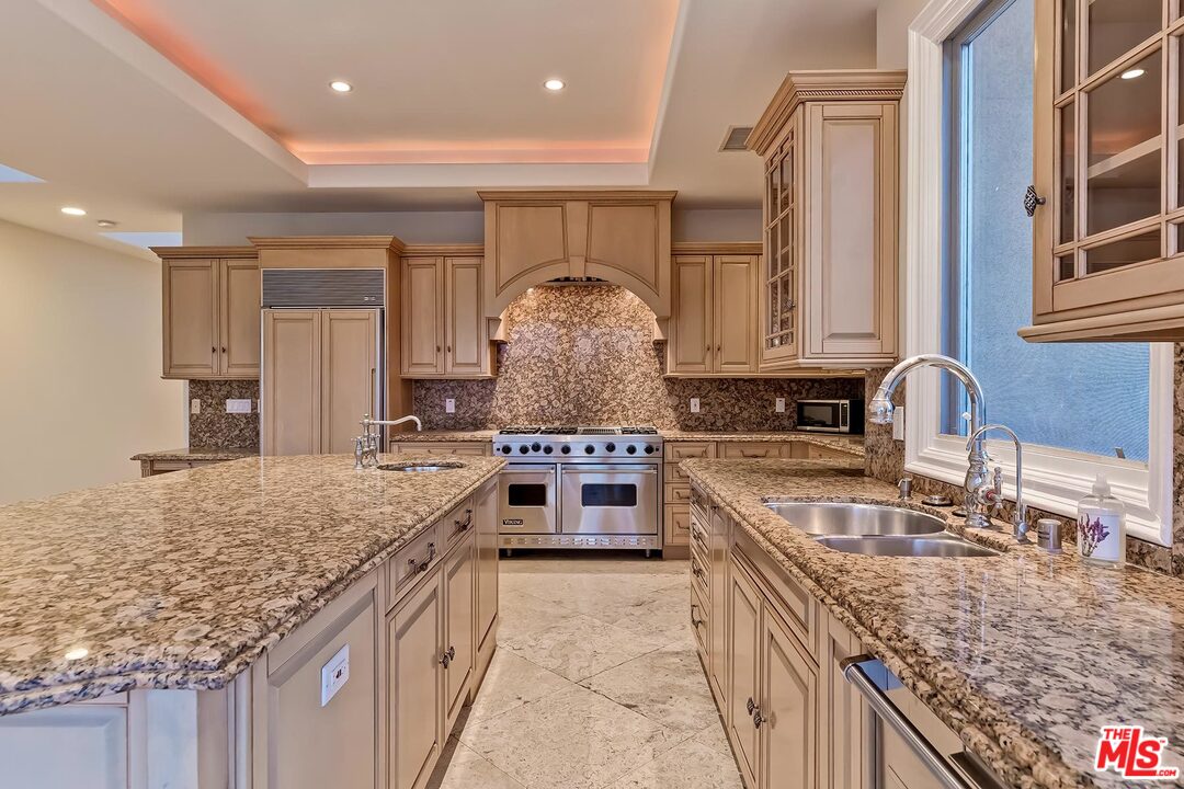 2121 Mt Olympus Drive Los Angeles, CA 90046 - Photo 20 of 34 a kitchen with stainless steel appliances granite countertop a sink stove and cabinets