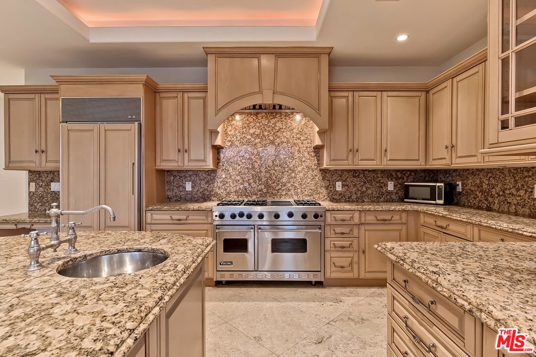 2121 Mt Olympus Drive Los Angeles, CA 90046 - Photo 21 of 34 a kitchen with stainless steel appliances granite countertop a stove sink and cabinets
