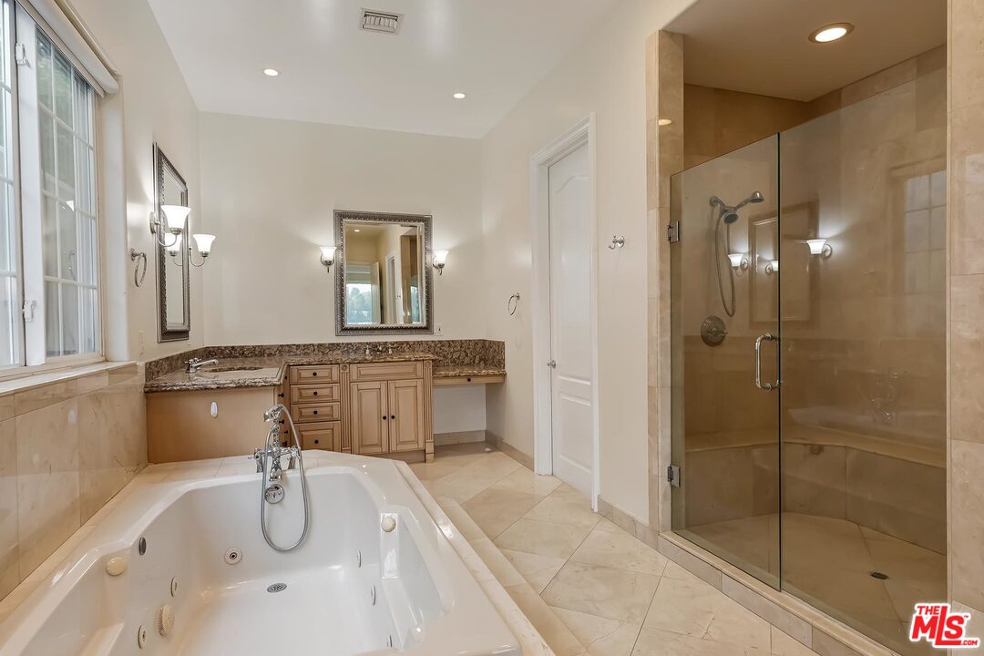 2121 Mt Olympus Drive Los Angeles, CA 90046 - Photo 25 of 34 a bathroom with a tub a double vanity sink and mirror