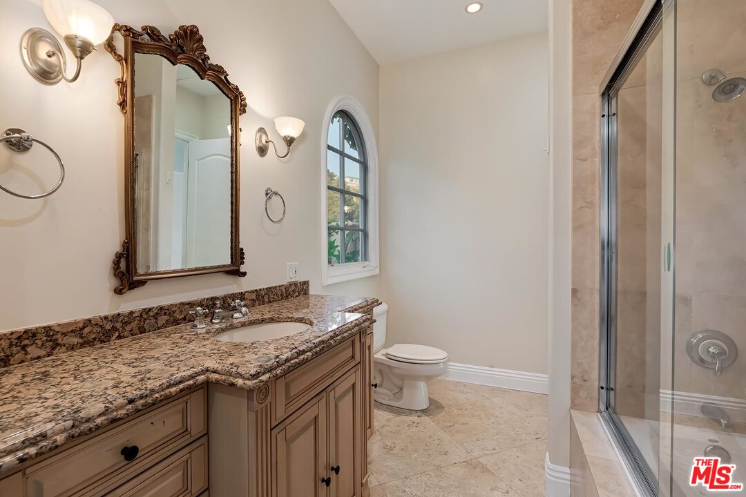 2121 Mt Olympus Drive Los Angeles, CA 90046 - Photo 27 of 34 a bathroom with a granite countertop sink a toilet and a mirror
