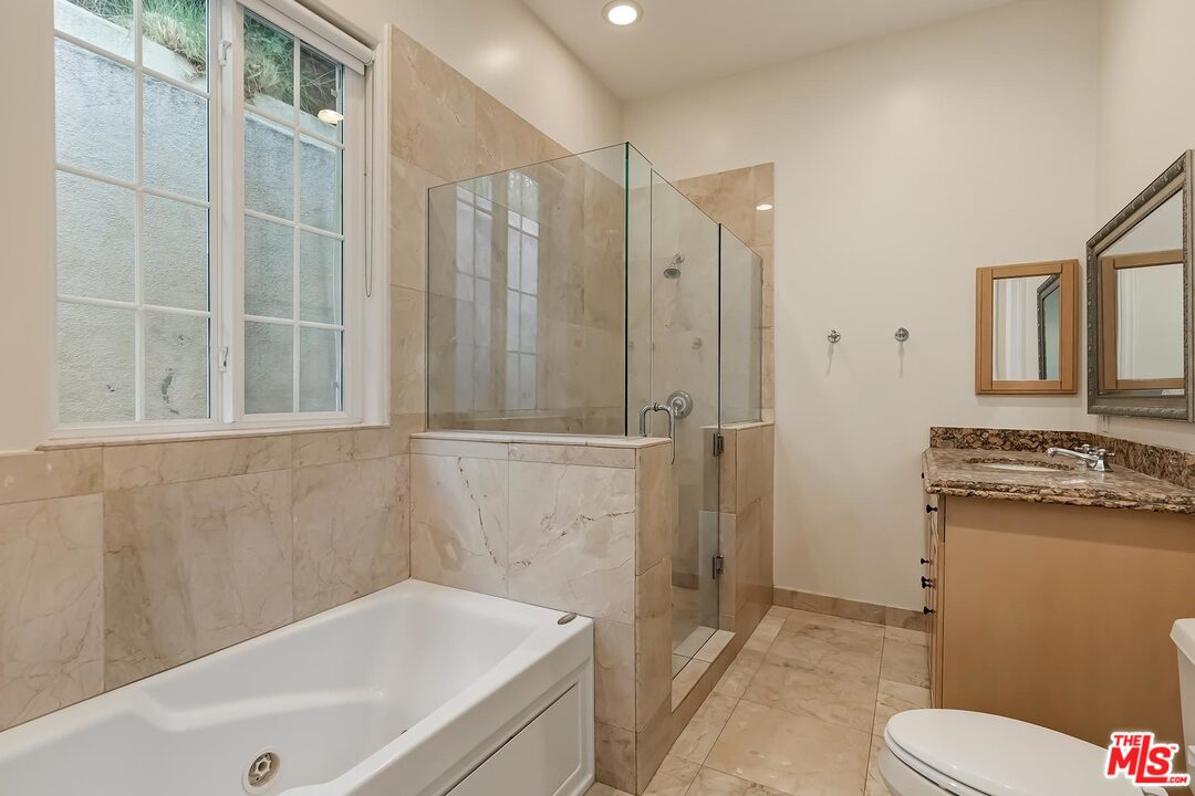 2121 Mt Olympus Drive Los Angeles, CA 90046 - Photo 30 of 34 a bathroom with a granite countertop sink toilet and shower