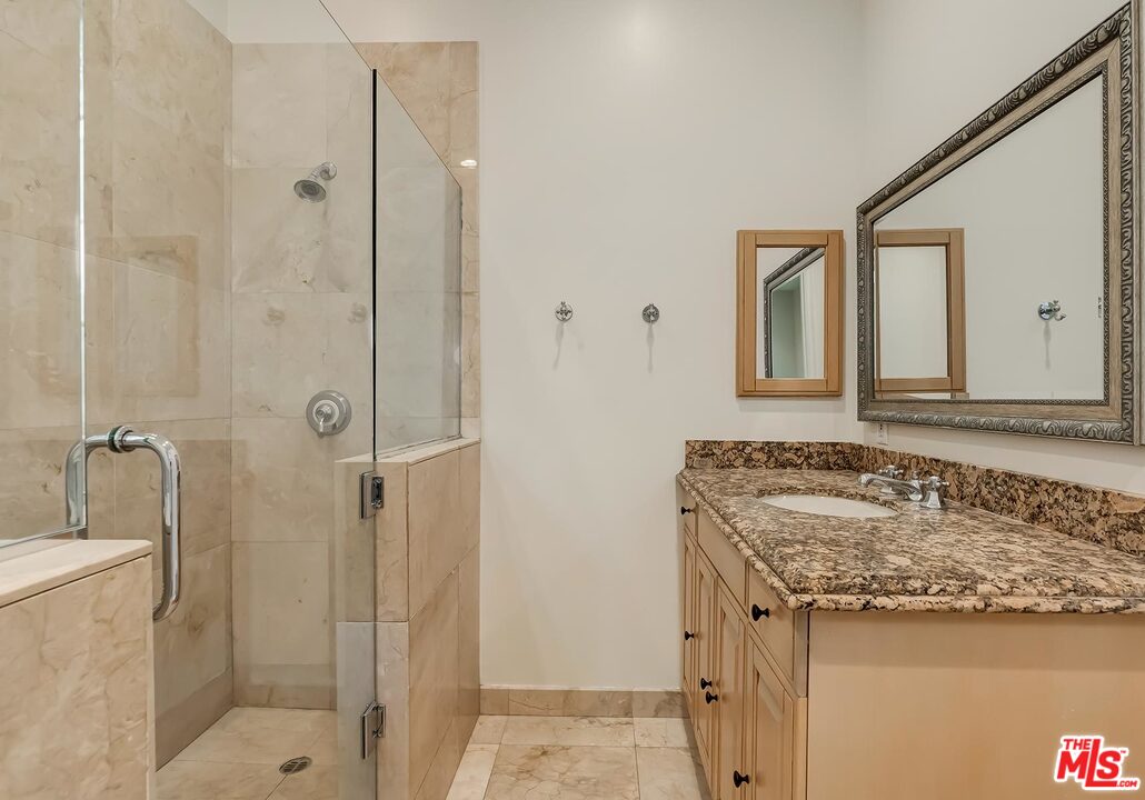 2121 Mt Olympus Drive Los Angeles, CA 90046 - Photo 31 of 34 a bathroom with a granite countertop sink and a mirror