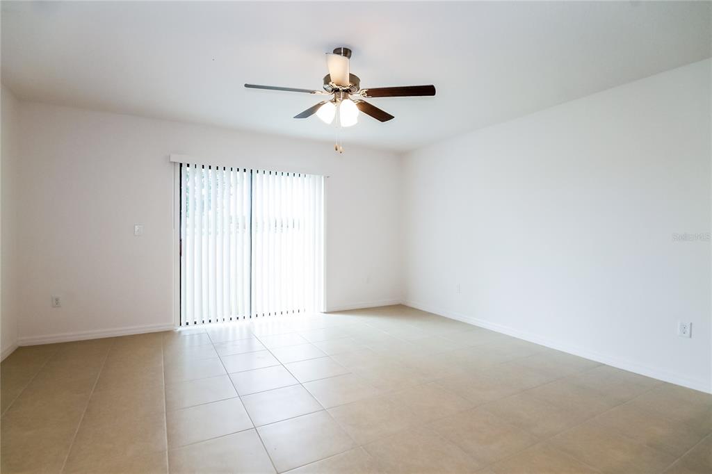 8615 Silverbell Loop Brooksville, FL 34613 - Photo 4 of 16 an empty room with windows and fan