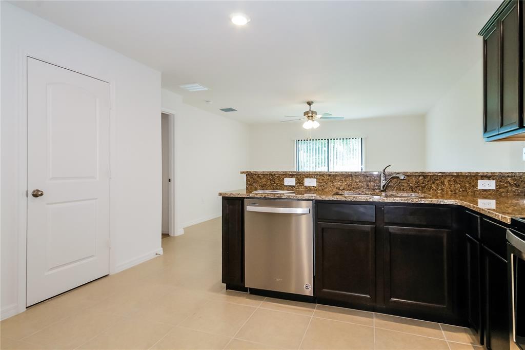 8615 Silverbell Loop Brooksville, FL 34613 - Photo 7 of 16 a kitchen with granite countertop a sink and cabinets